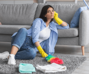 A woman sitting on the floor with a cleaning brush.