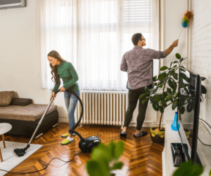 A man and woman cleaning the floor of their home.