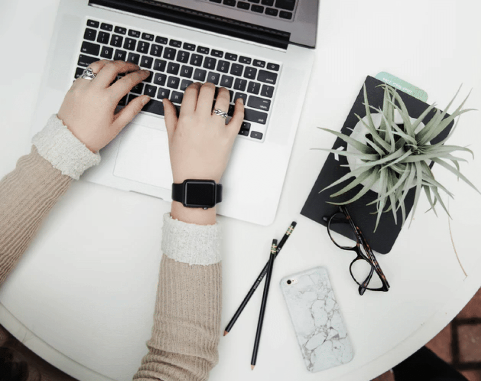 A person using their laptop on the desk