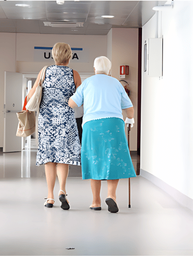 Two elderly women walking down a hallway holding hands.