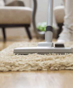 A person using a vacuum on the floor