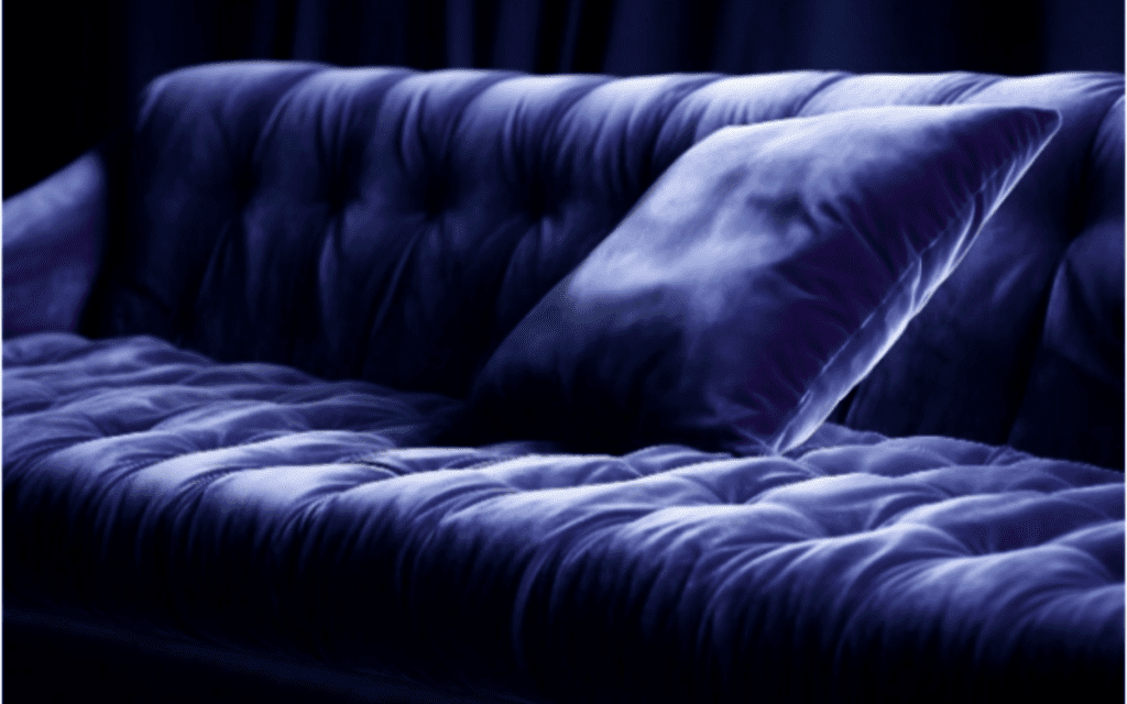 A purple couch with pillows on it.