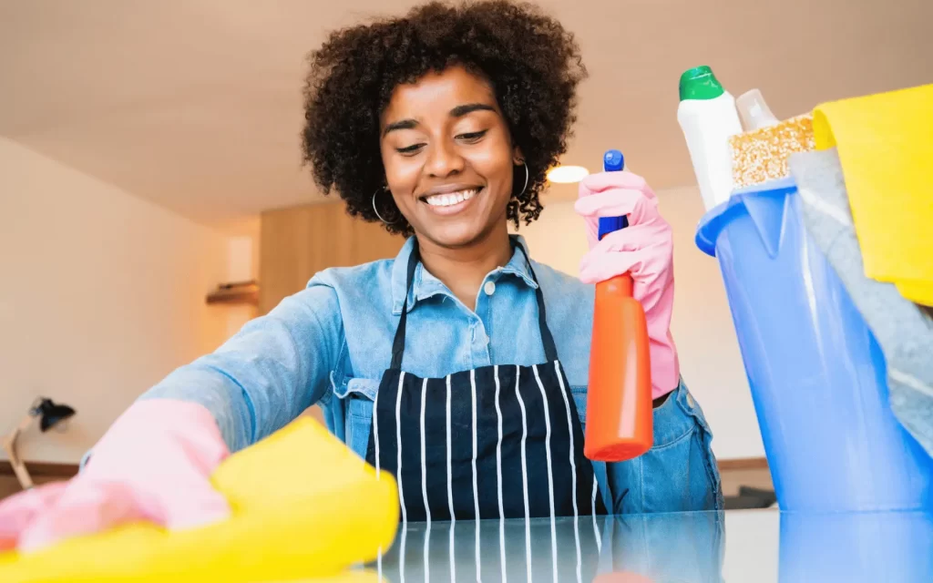 A woman is cleaning the counter top