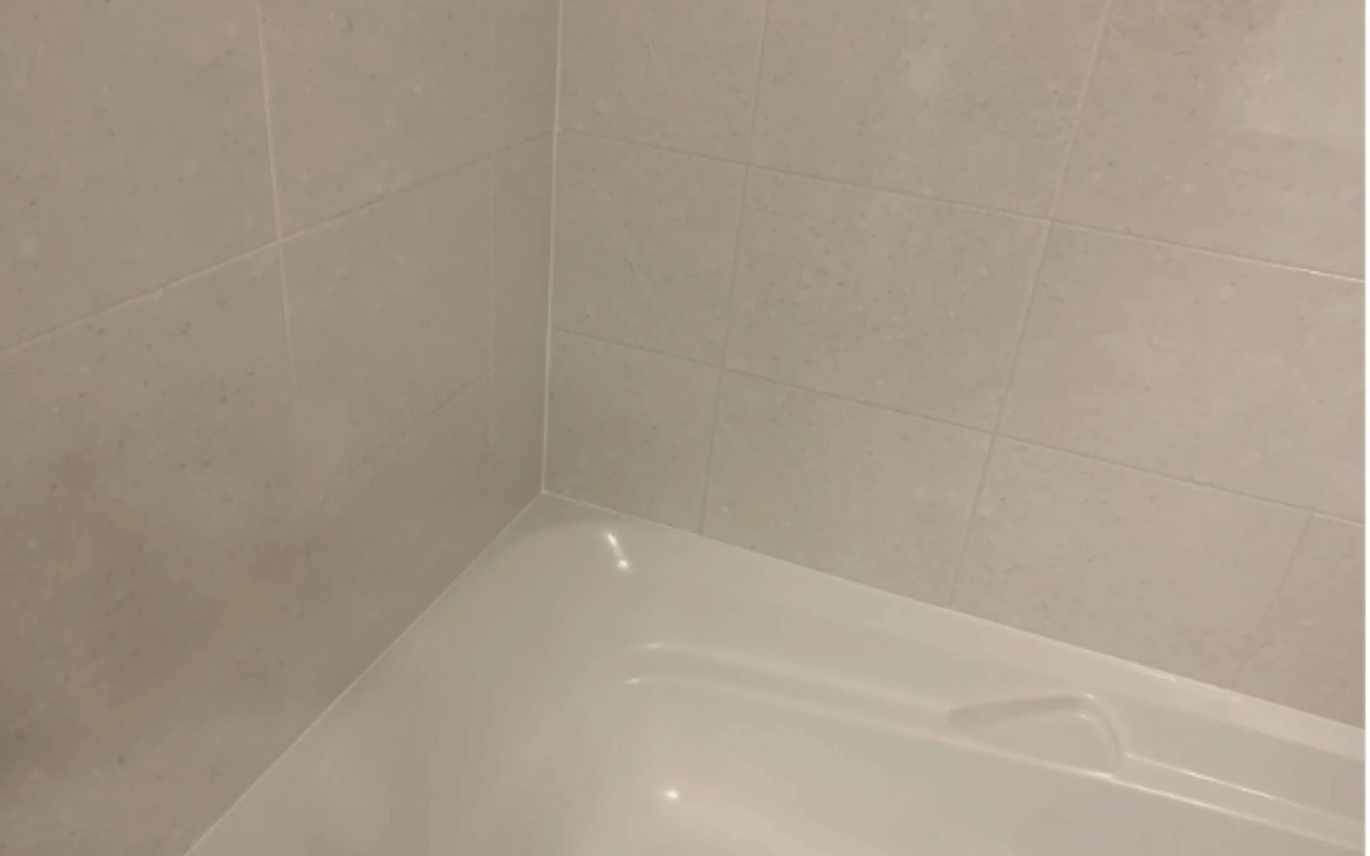 A white bathtub with a wall in the background